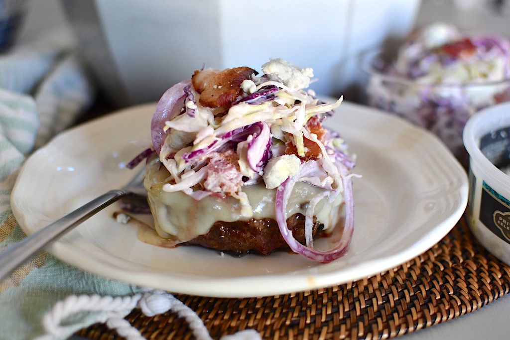 keto blue cheese coleslaw with bacon on top of cheeseburger 