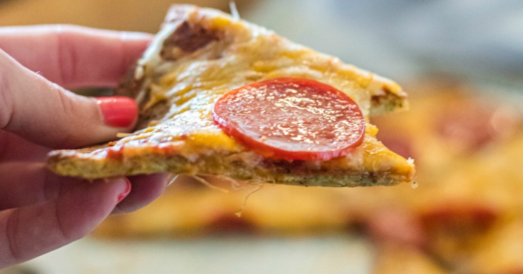 holding pork rind crust pepperoni pizza 