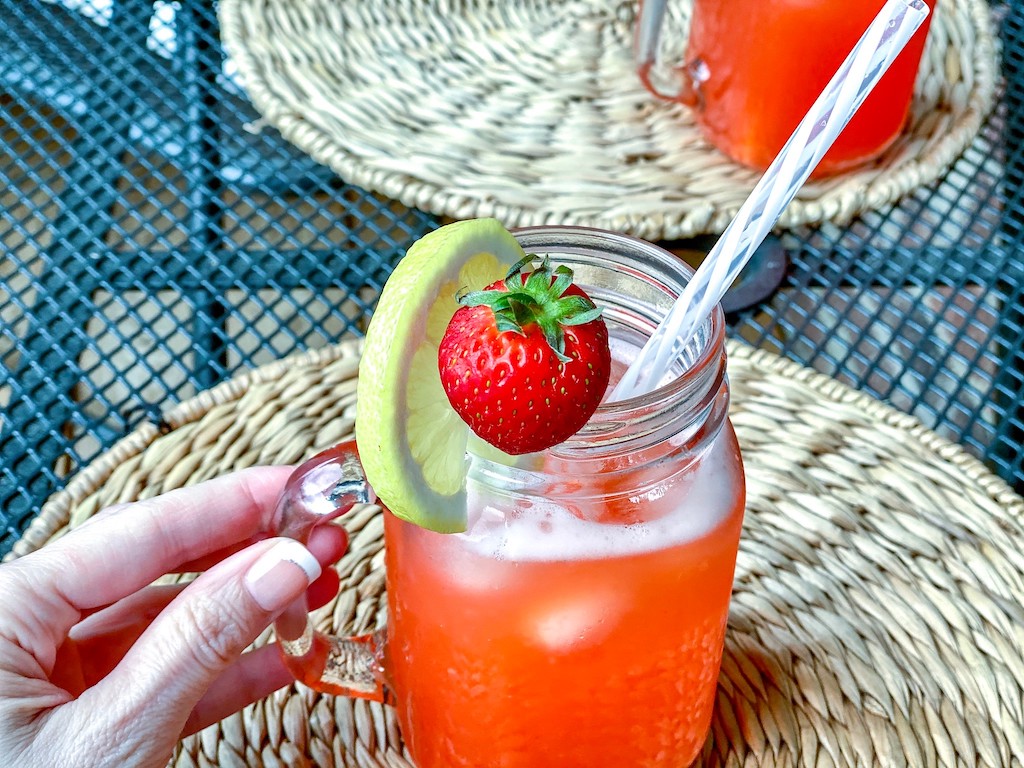 holding mason jar filled with keto strawberry lemonade 