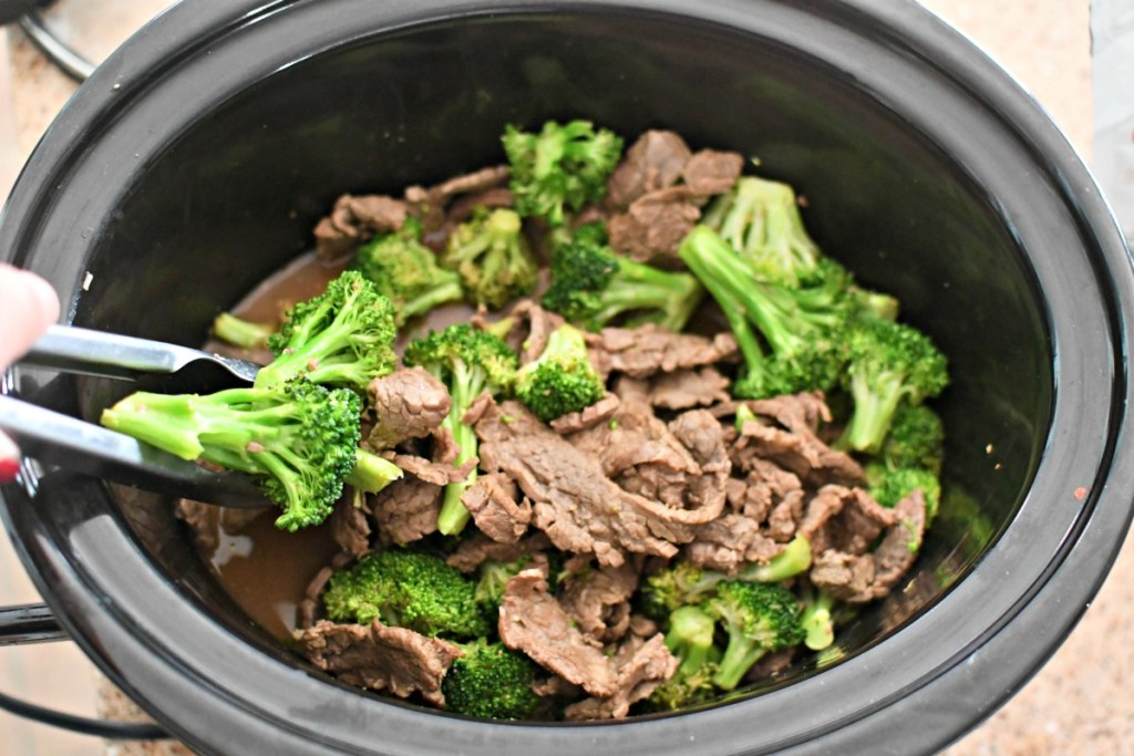 mixing keto beef and broccoli with tongs