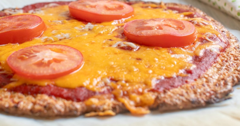 pork rind pizza crust with cheese and sliced tomatoes 