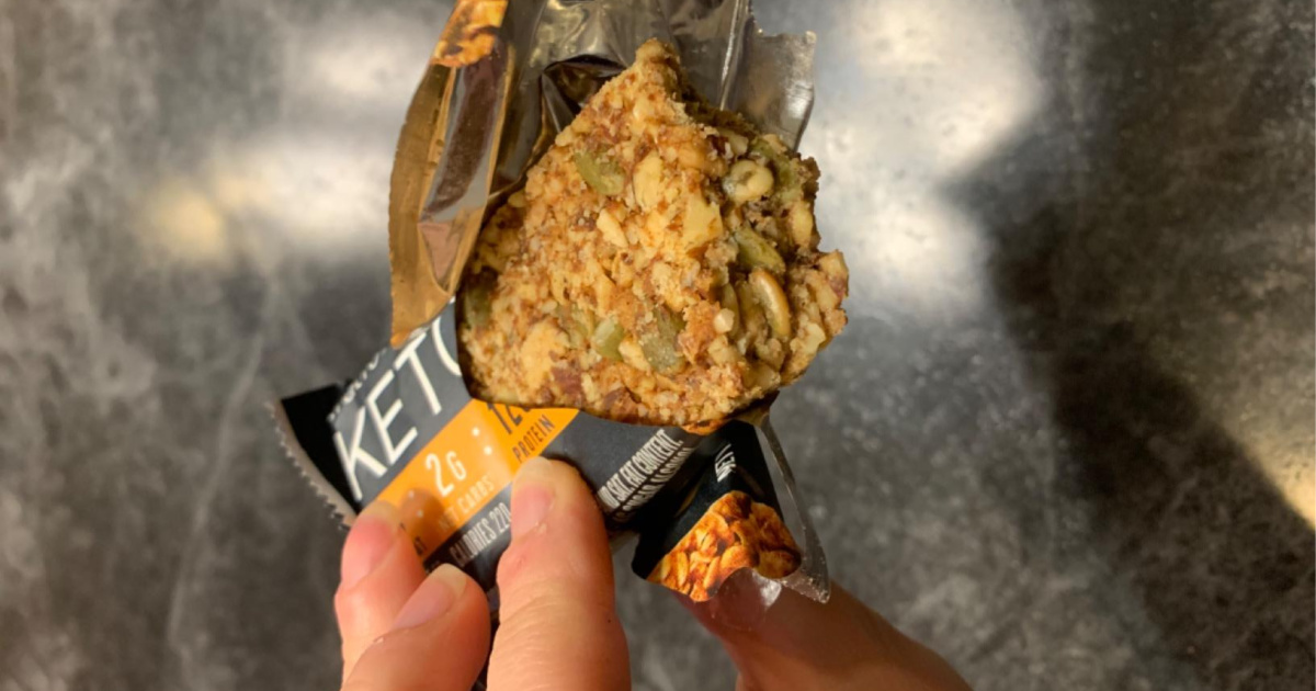 hand holding opened ratio keto protein bar