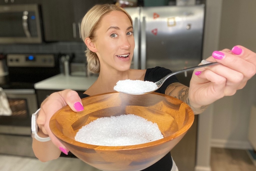 woman holding bowl of salt with spoon 