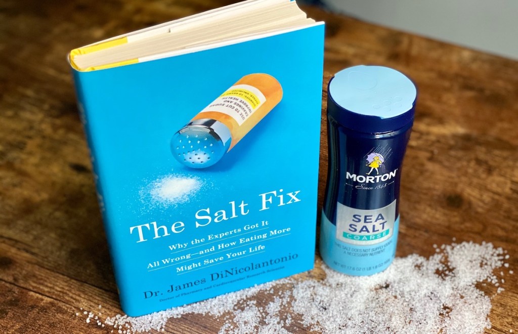 the salt fix book on wood table with salt jar spilled on top