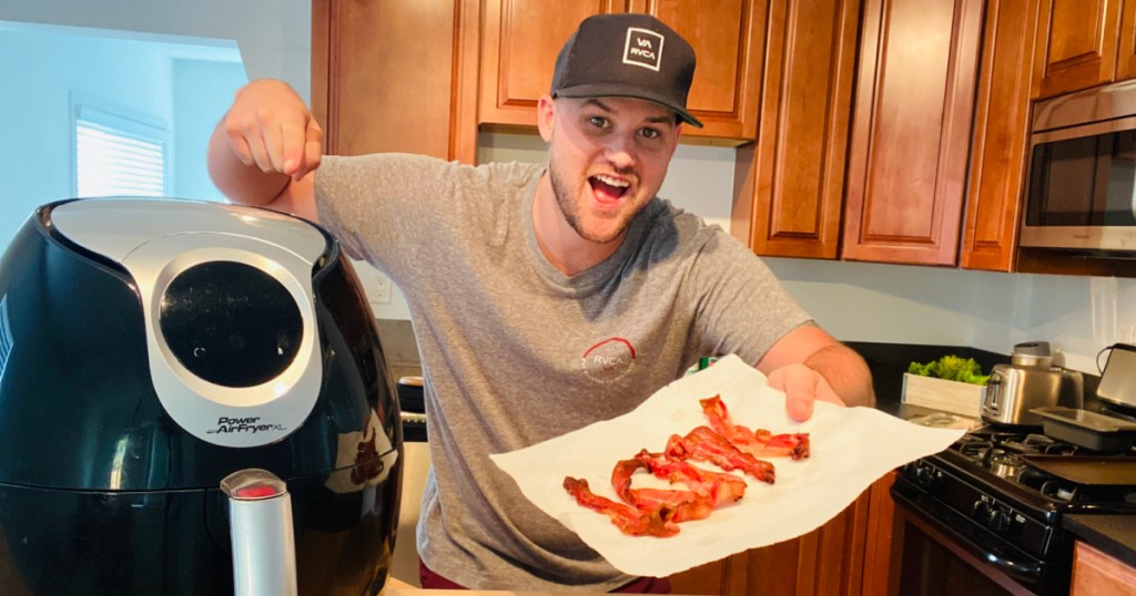 guy holding a plate of bacon