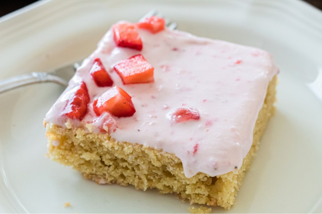 slice of keto almond cake with berry frosting