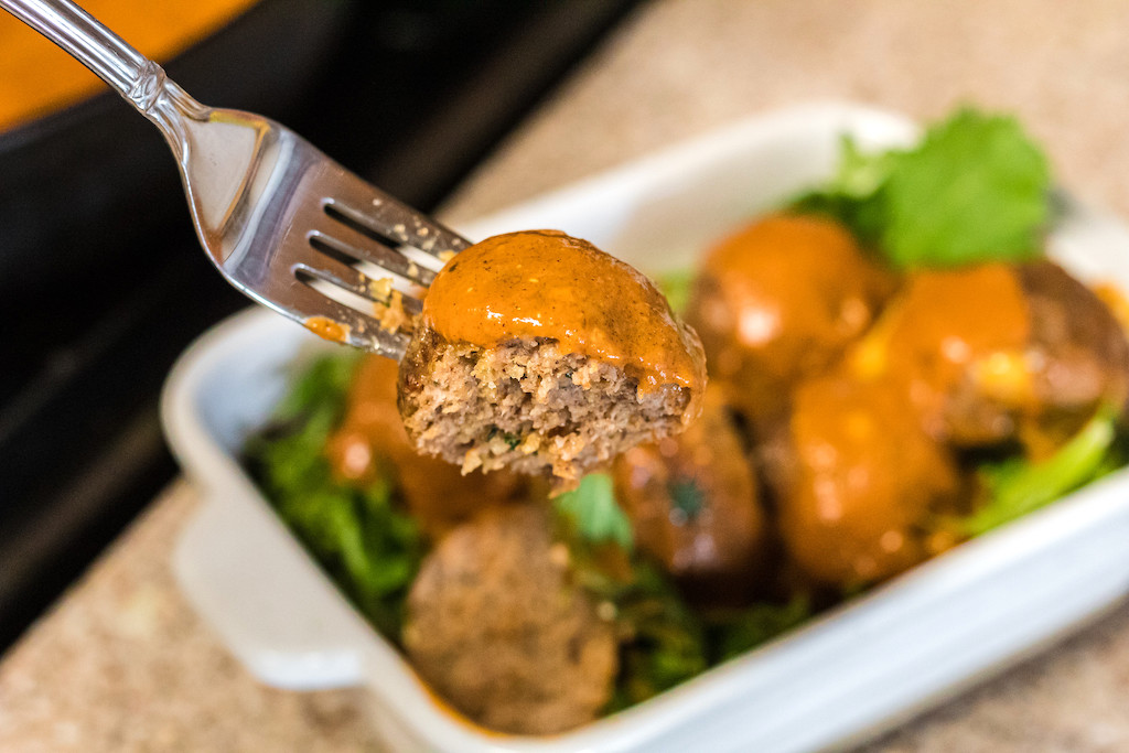 keto meatball on fork with pumpkin sauce 