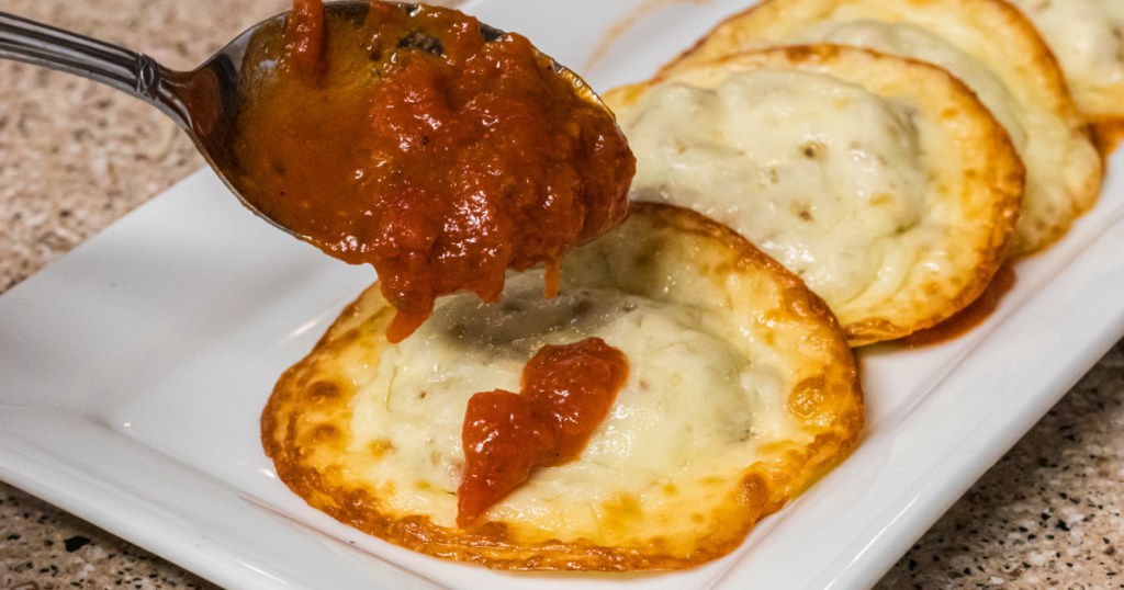 marinara being poured on keto ravioli 