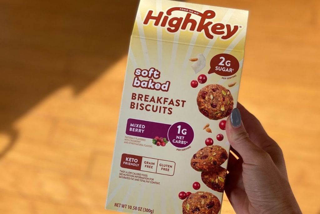 A hand holding a box of mixed berry breakfast biscuits