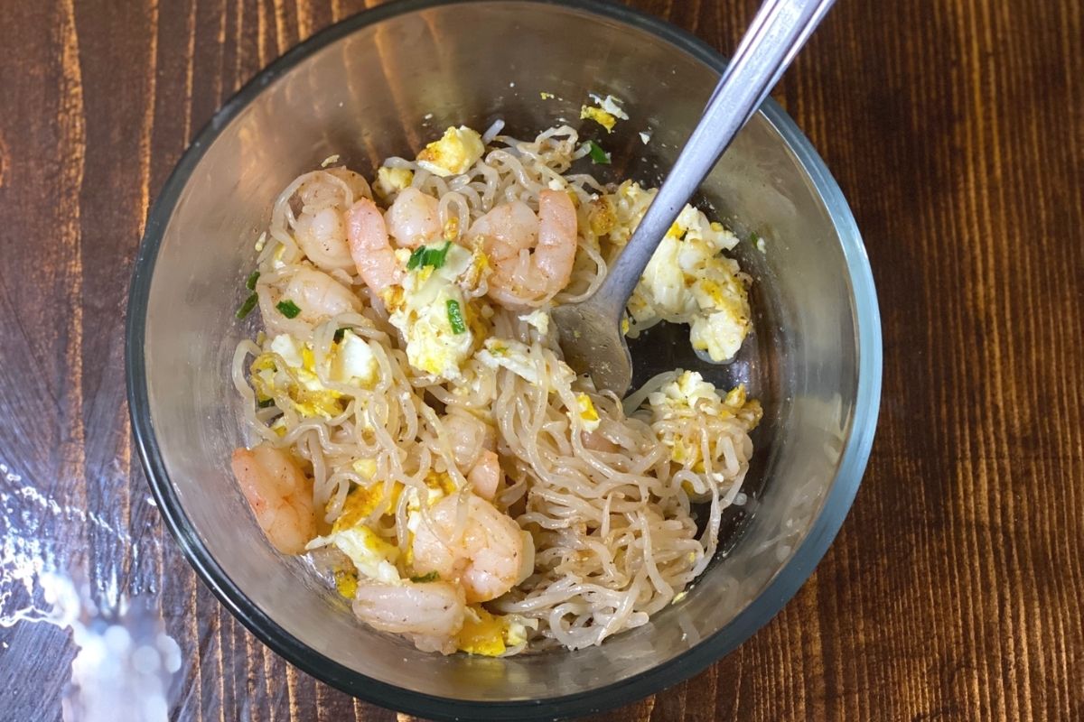 A ramen bowl with shrimp and egg on a table