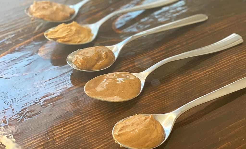 5 spoonfuls of almond butter lined up on a table