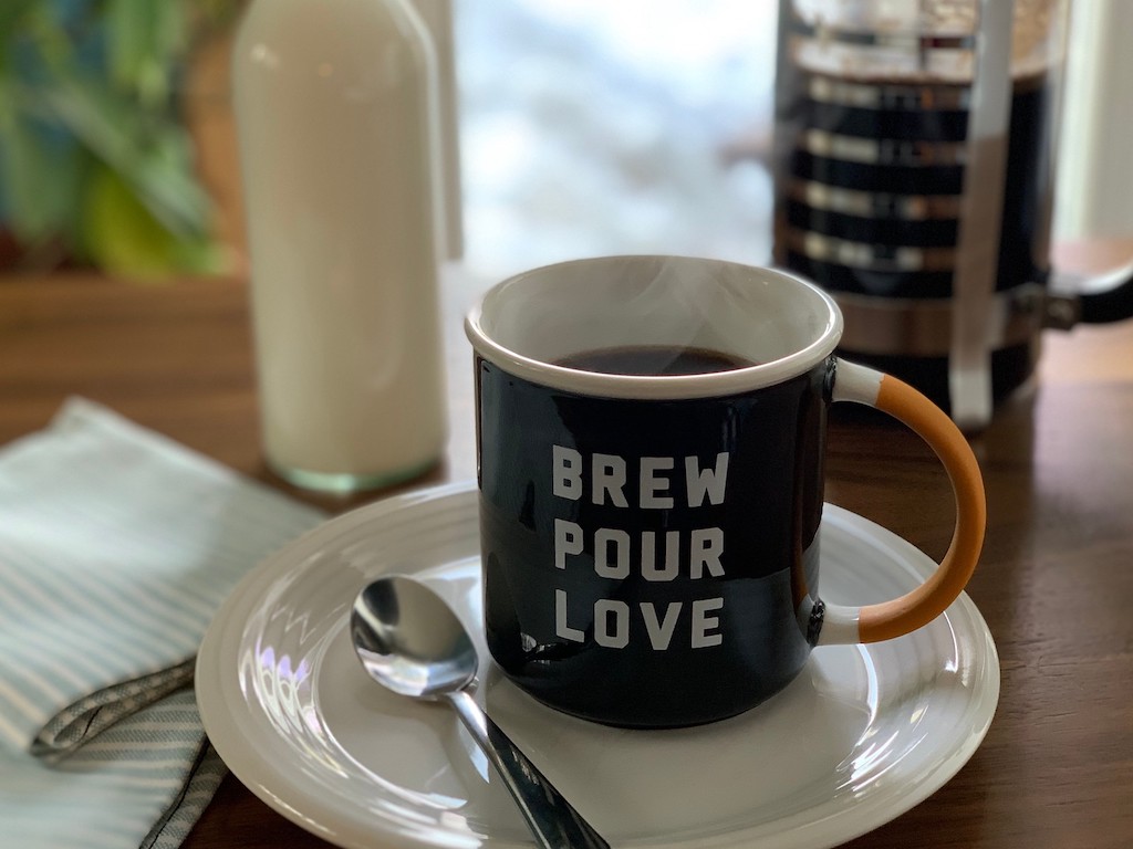 coffee mug on plate with black coffee 