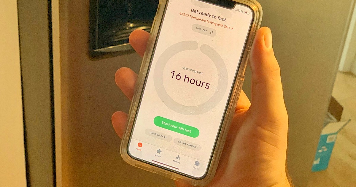 holding a phone with a keto and intermittent fasting app