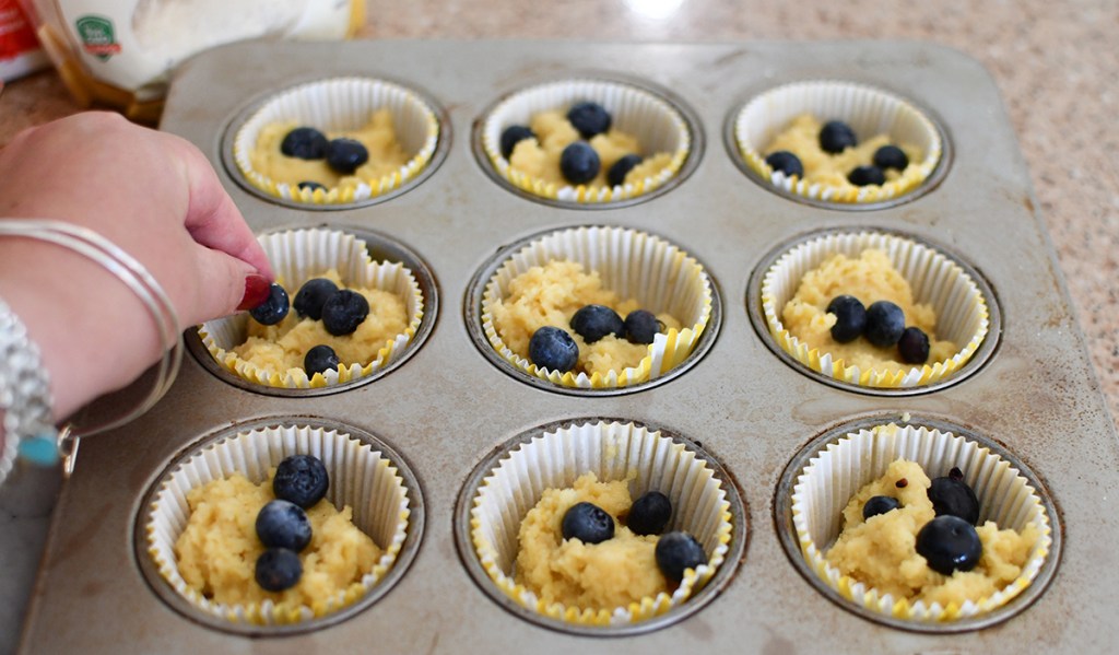 adding blueberries to muffin batter