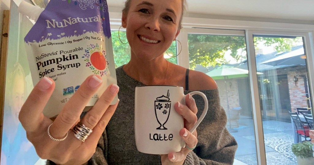 woman holding NuNaturals pumpkin spice syrup 