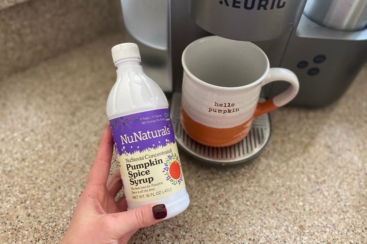 NuNaturals sugar free pumpkin spiced syrup in front of Keurig coffee maker and cup