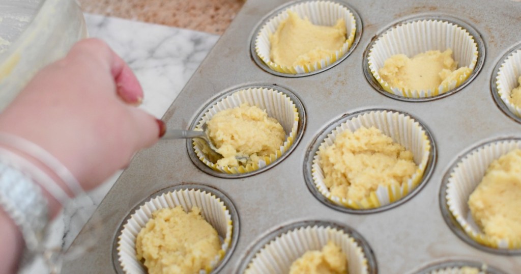 placing muffin batter into muffin tin