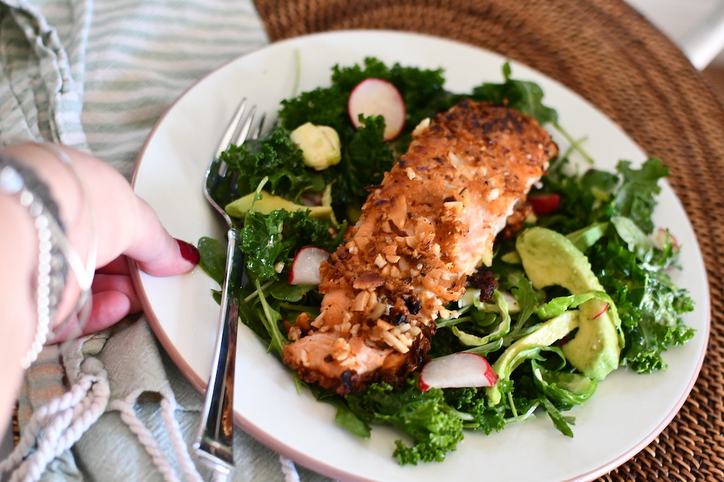 salad greens, avocado slices, and salmon on plate 