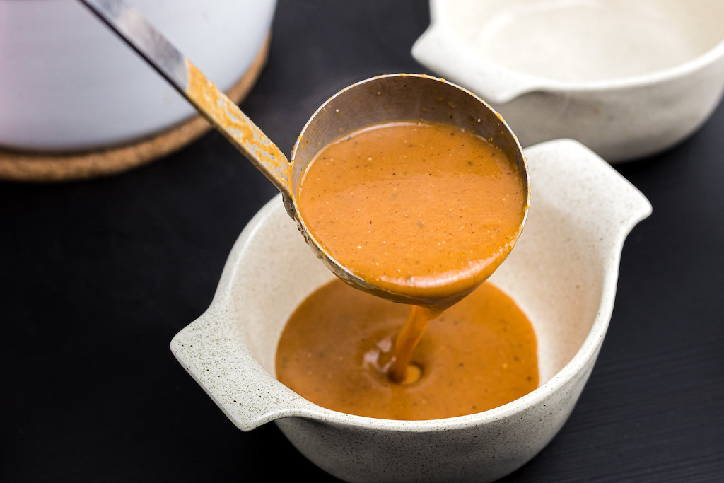 pouring keto pumpkin soup into bowl 