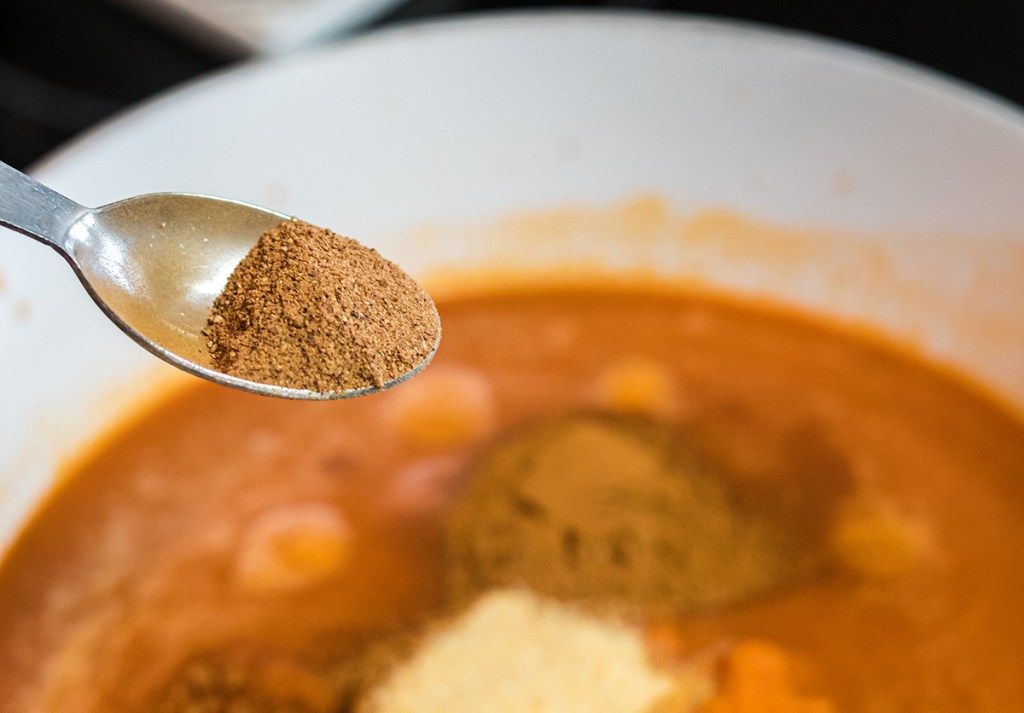 adding in spices to keto pumpkin soup