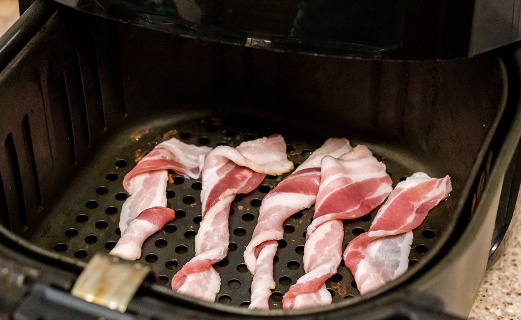 strips of bacon twisted in an air fryer basket