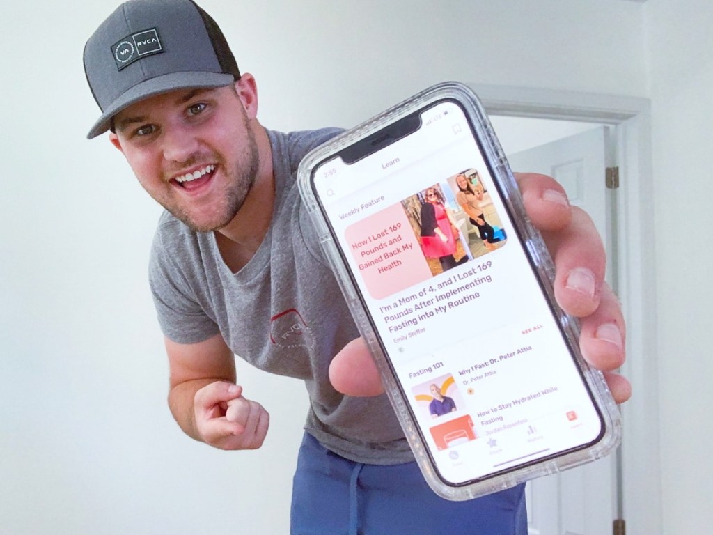 man holding iPhone open to fasting app