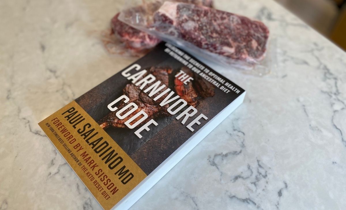 A book on a counter next to some steak