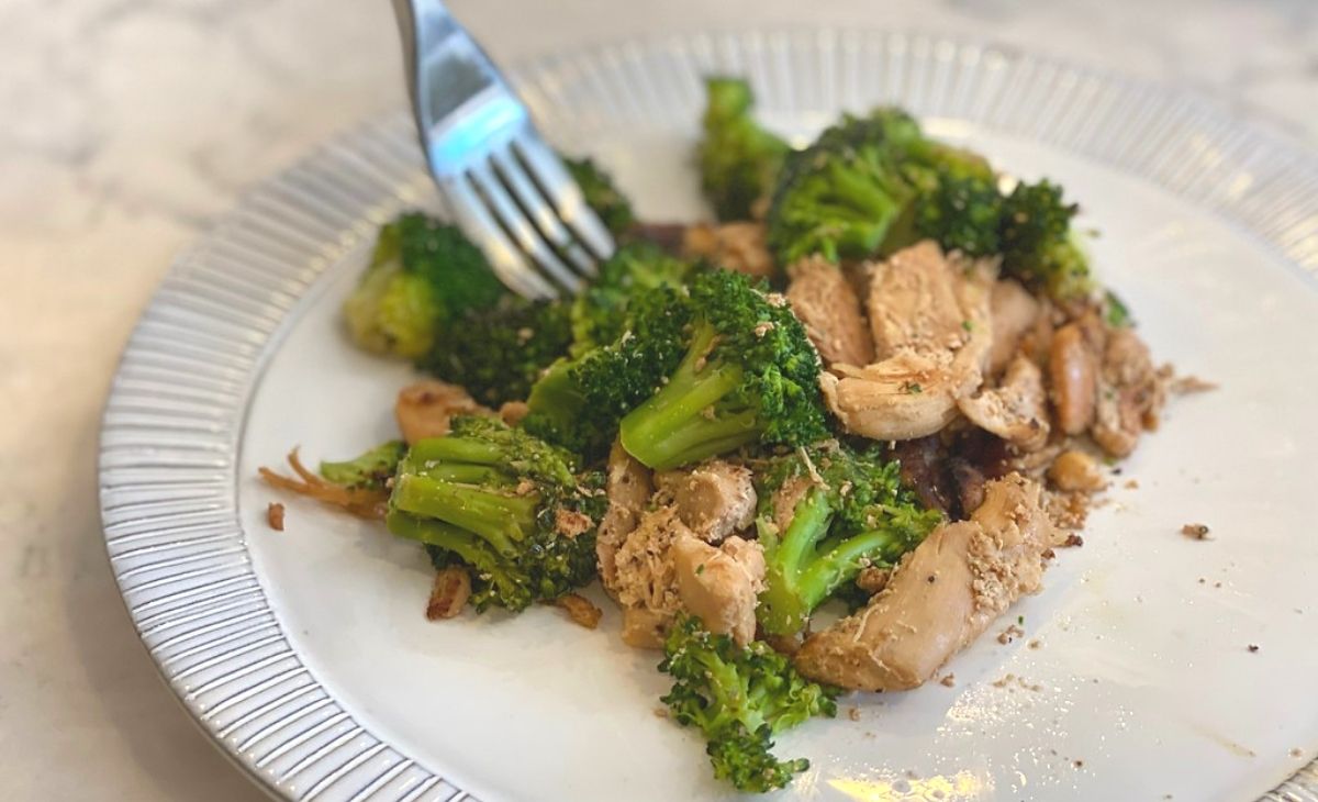 Broccoli and chicken on a plate with a fork