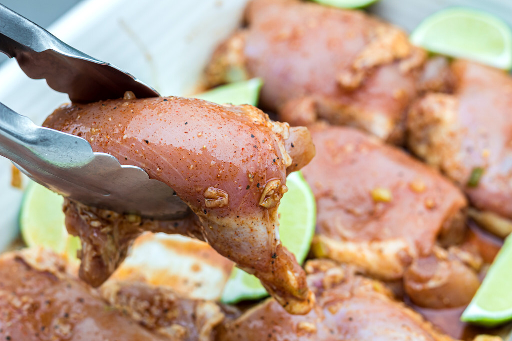 using tongs to pick up keto jerk chicken 