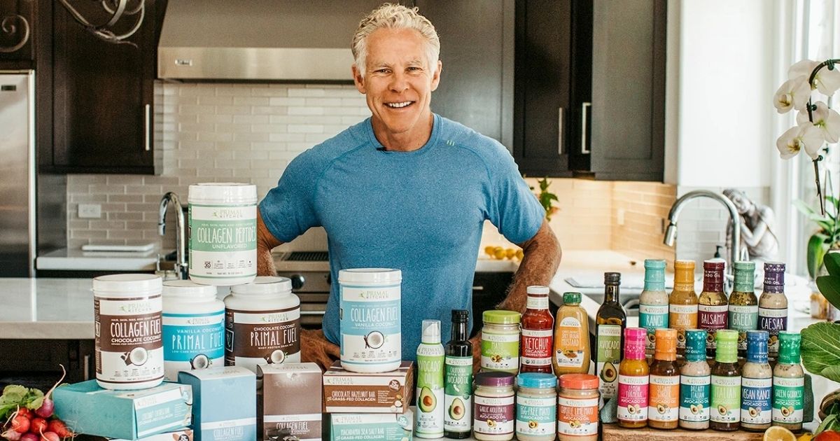 A man in a kitchen with Primal Kitchen products on the counter