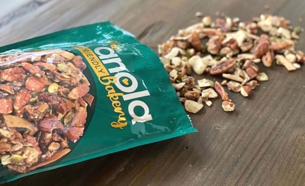 A bag of granola on a table with some spilling out