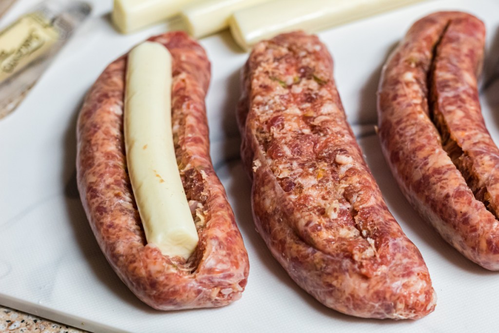 cheese stick in sausage on cutting board