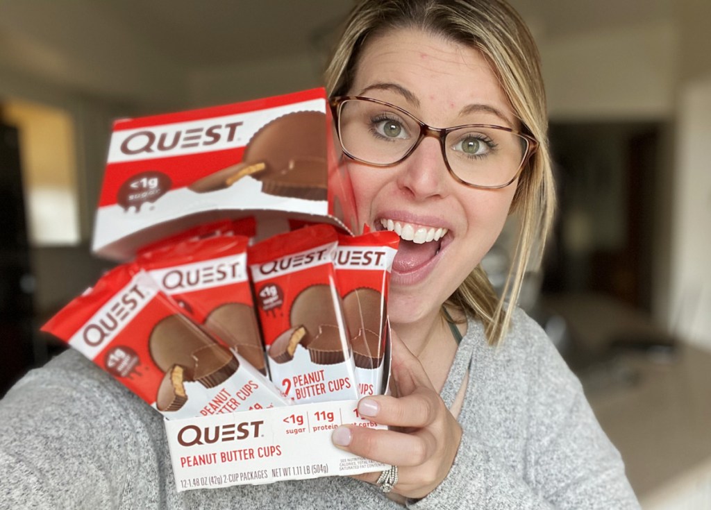 woman holding box of quest peanut butter cups