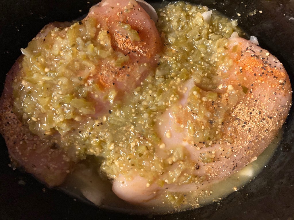 chicken with green salsa and seasonings in Crockpot