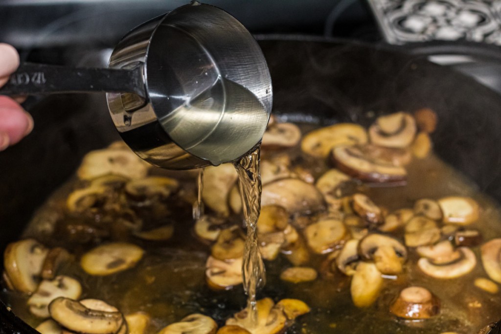 cooking wine being poured into skillet