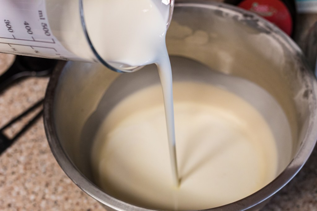 pouring heavy cream into bowl