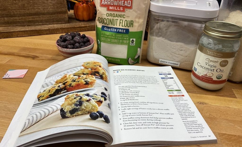 A cookbook on a counter next to ingredients