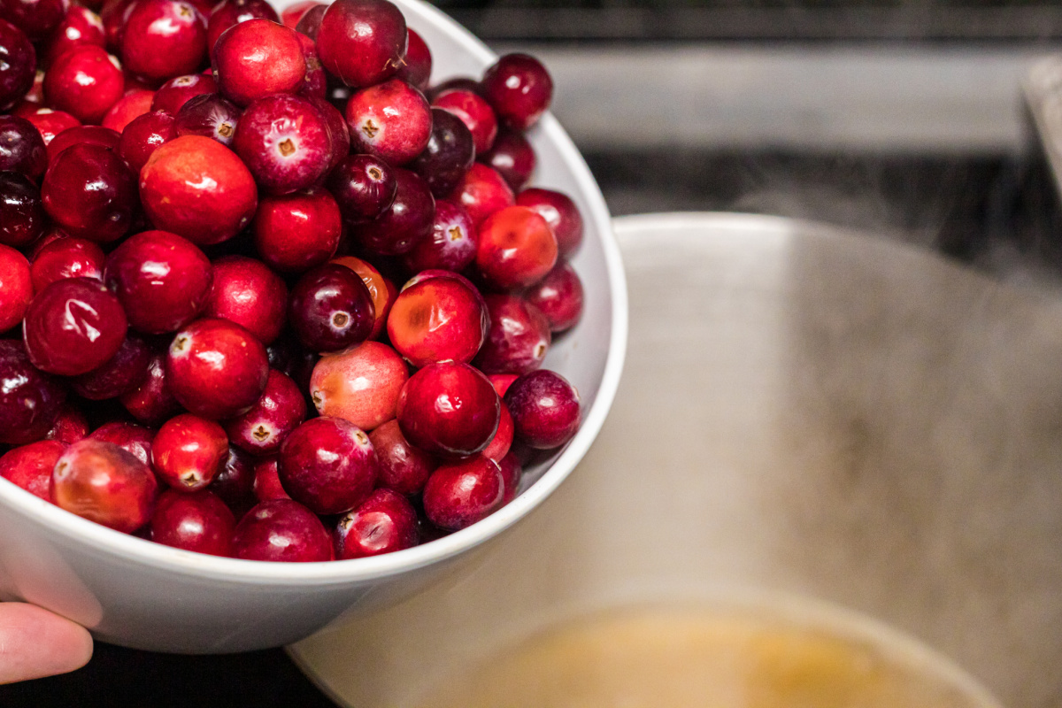 pouring cranberries into saucepan - low carb fruits