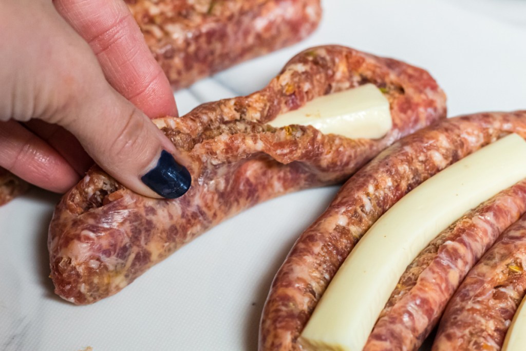 stuffing an Italian sausage link with a cheese stick