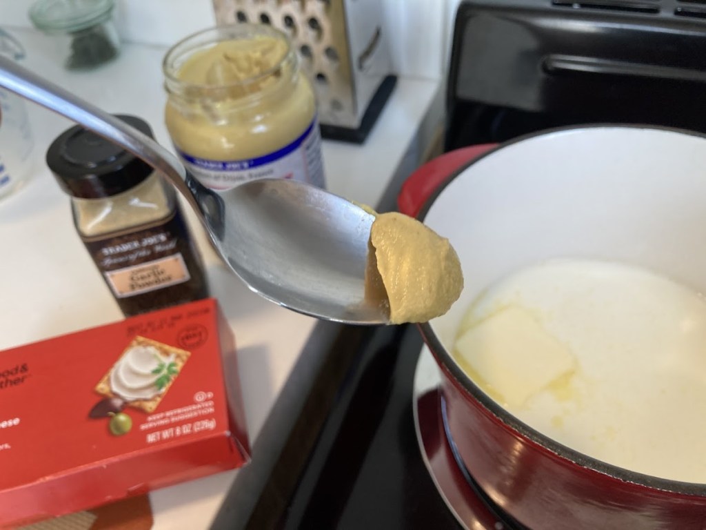 adding dijon mustard to saucepan