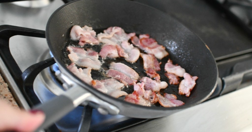 cooking bacon pieces on a skillet