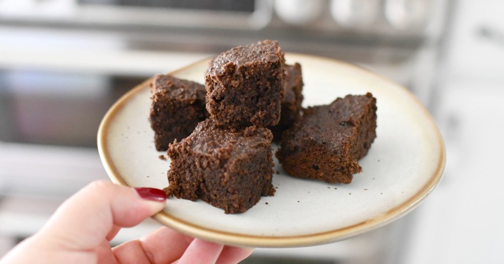 holding a plate of super fat brownies in front of oven