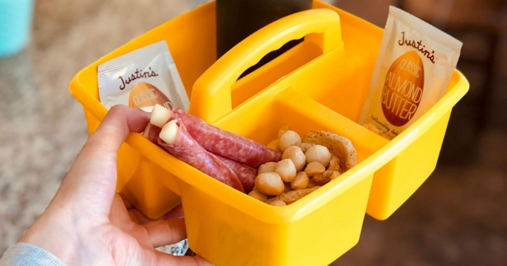 holding carton filled with keto movie snacks 