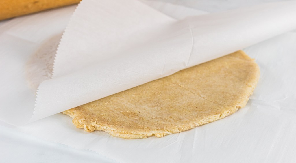 rolling keto dough in parchment paper