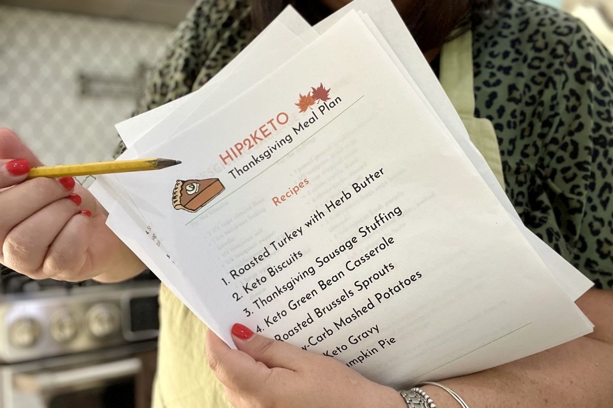 woman pointing to a keto Thanksgiving recipe list
