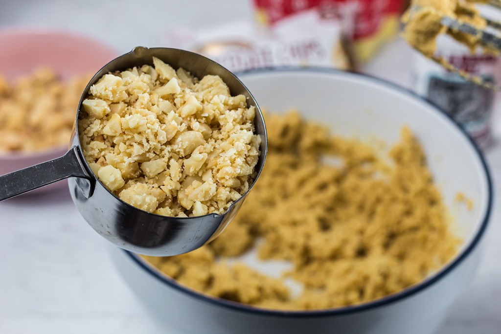 measuring cup with crushed macadamia nut cookies