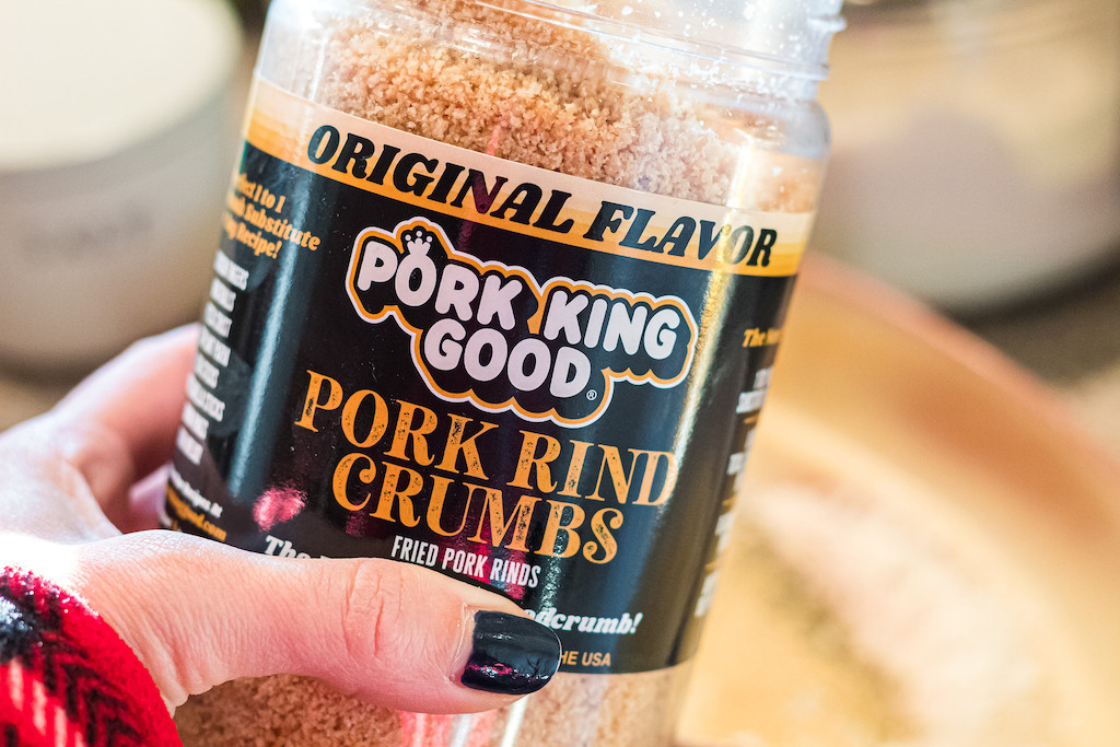 holding container of Pork King Good pork rind crumbs
