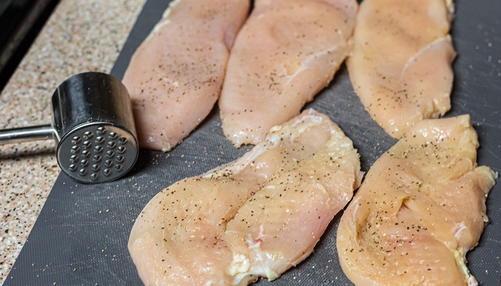 chicken breast with meat mallet after being tenderized