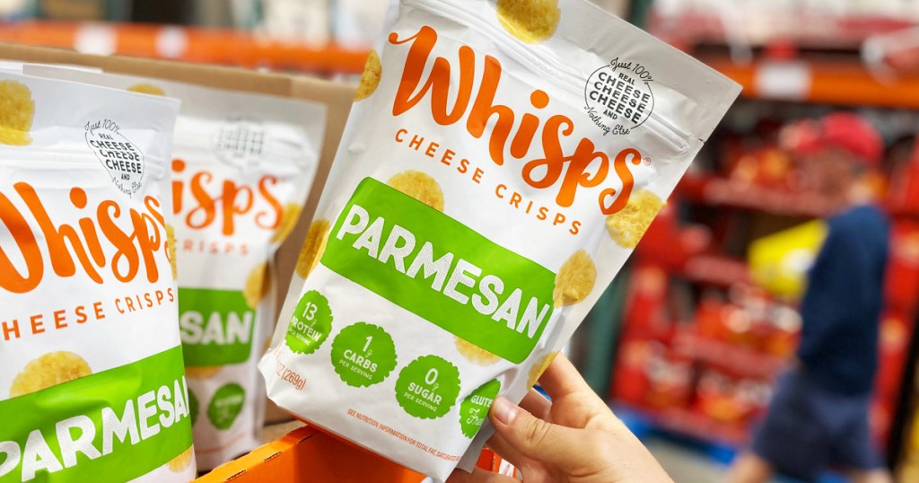 hand holding a bag of whisps at costco - costco instant savings - keto costco