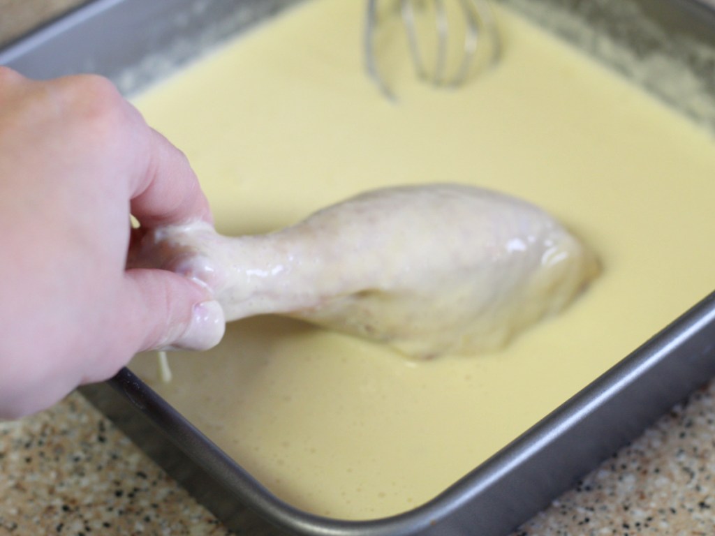 drenching drumstick in an egg wash